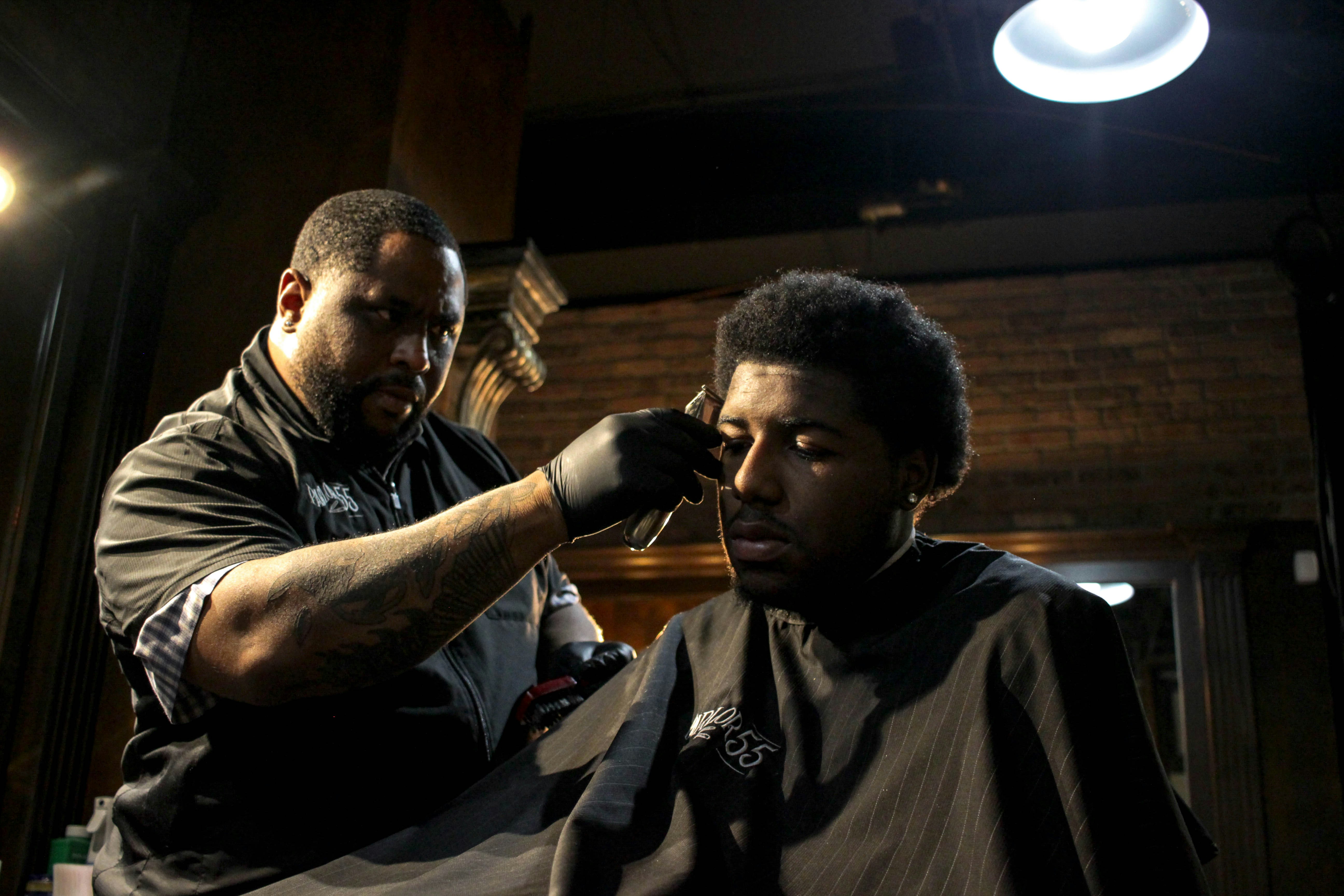 A barber giving a customer a haircut in a barbershop